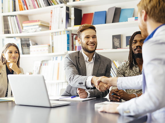 A local business owner shaking hands with a new customer who found them through a nearby search